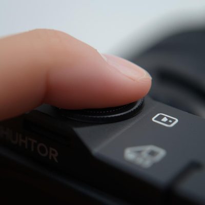 doigt appuyant sur un appareil photo